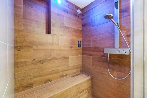 阿姆斯特丹170M2 Appartment with Jacuzzi & Steam bath in center of Amsterdam的带淋浴的浴室和木墙