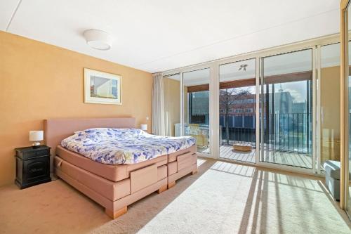 阿姆斯特丹170M2 Appartment with Jacuzzi & Steam bath in center of Amsterdam的一间卧室设有一张床和一个大窗户