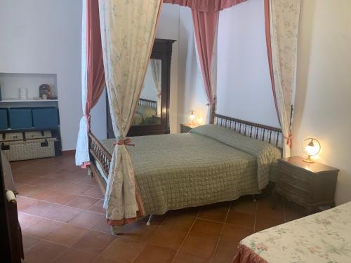 马拉泰亚La dimora di Adelaide的一间卧室配有两张床和两盏灯。