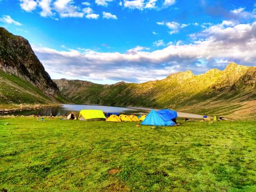 帕哈尔加姆Kashmir Outlook Adventures的一群帐篷位于湖边的田野