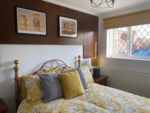 梅里登The Daytona - Triumph Apartments Meriden NEC 6.5m的一间卧室配有黄色和蓝色枕头的床