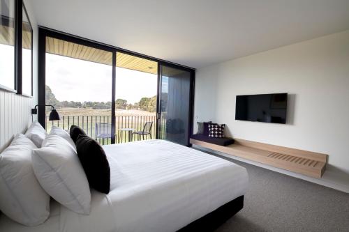 CurlewisAccommodation @ Curlewis的卧室配有一张白色大床和电视。