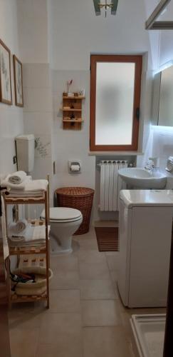 吉诺萨滨海CASA ADA的浴室配有盥洗盆、卫生间和盥洗盆。