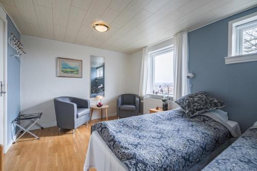 Slettestrand霍伊加登酒店的卧室配有床、椅子和窗户。