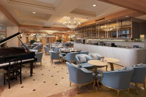 高雄汉来大饭店的一间设有钢琴和桌椅的餐厅