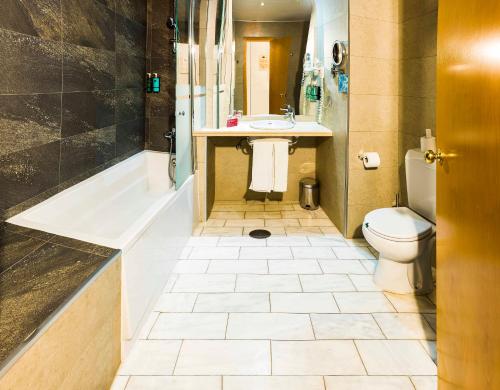 塞维利亚塞维利亚贝拉维斯塔酒店的带浴缸、卫生间和盥洗盆的浴室