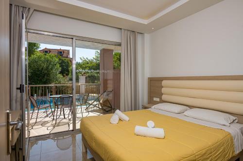 卡拉马孔Caretta Beach Resort & WaterPark的一间卧室设有一张黄色的床和一个阳台