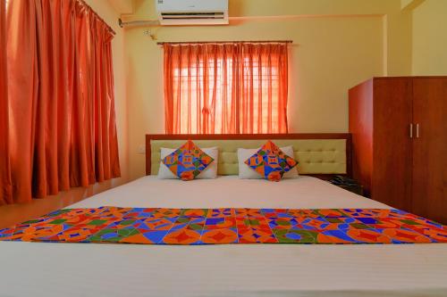 加尔各答FabHotel Capital Casa的一间卧室配有一张大床和色彩缤纷的被子