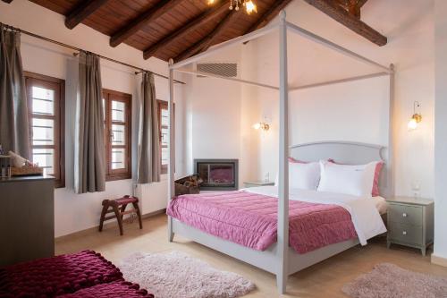 帕莱斯潘蒂雷蒙Guesthouse Ourania的一间卧室配有一张带粉红色床罩的天蓬床
