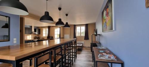 维莱科特雷圣雷米度假屋的厨房配有带椅子的长木酒吧