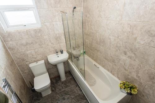 曼彻斯特M18 Abbey Hey Guesthouse的浴室配有卫生间、盥洗盆和淋浴。