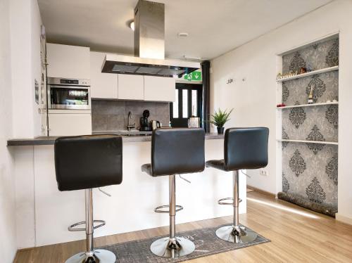 阿姆斯特丹Studio with sauna的厨房在柜台前设有两个吧台凳