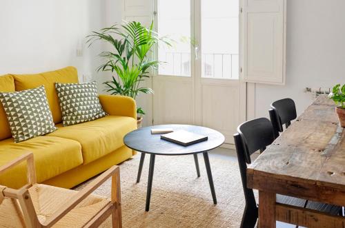 巴塞罗那格劳生态精品酒店的客厅配有黄色的沙发和桌子