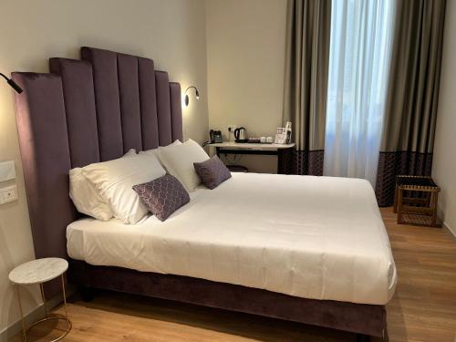 佛罗伦萨Corte dei Sogni Boutique Hotel & spa的一间卧室配有一张大床和大床头板