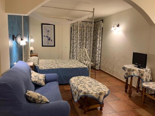 Cerezo de Abajo兰加酒店的客厅配有蓝色的沙发和床。