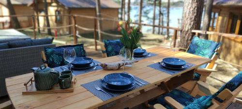 博尔斯克Domek Borsk nad samym jeziorem的一张带蓝色盘子和玻璃杯的木桌