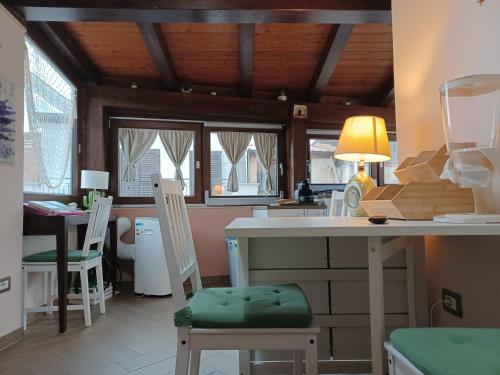 希拉IL Ritratto casa vacanza的厨房配有两把椅子和一张带台灯的桌子