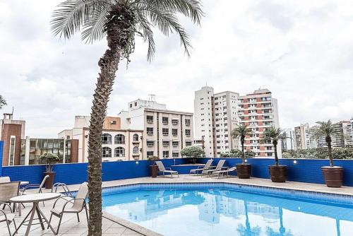 维多利亚维多利亚舒适套房酒店的一座棕榈树和建筑的游泳池