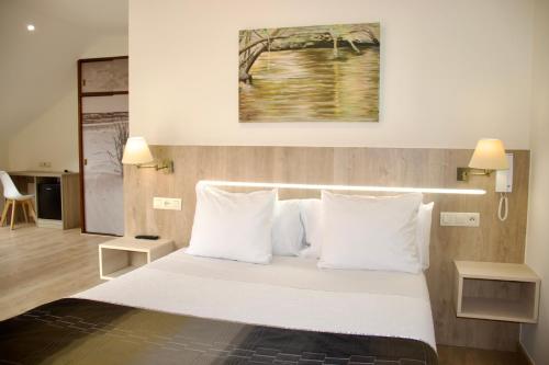穆希亚Hotel Playa de Lago的一间卧室配有带白色床单和枕头的床。