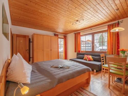 巴特霍夫加施泰因兰德施魏格尔公寓的一间卧室配有一张床、一张桌子和一张沙发