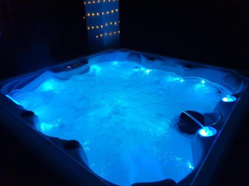 灵伍德Lions Lodge: Great location with hot tub的暗室里带灯的蓝色热水浴池