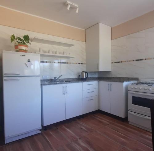 圣拉斐尔Finca La Calma的厨房配有白色橱柜和白色冰箱。