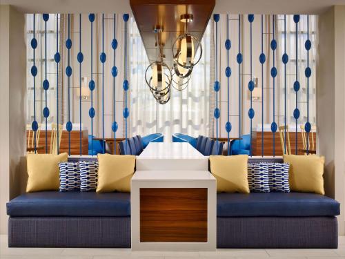 萨默塞特萨默塞特索尼斯塔ES套房酒店的客厅配有蓝色的沙发和吊灯。