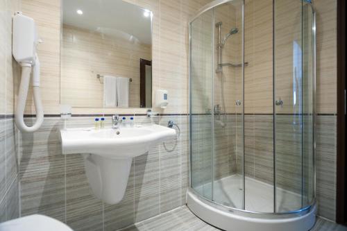 阳光海滩Grenada Hotel的一间带水槽和玻璃淋浴的浴室