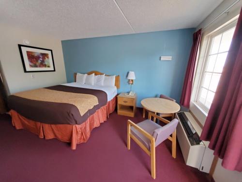 布兰森纺车旅馆的酒店客房配有一张床铺和一张桌子。