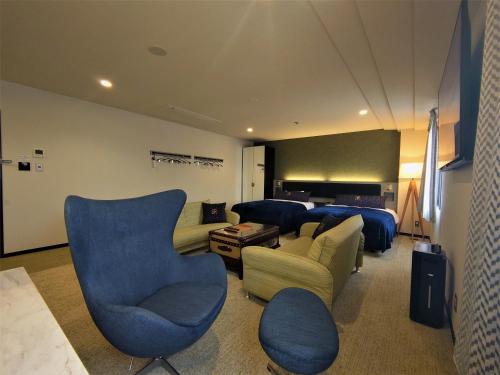 松江市Green Rich Hotel Matsue Station Across - Artificial hot spring Futamata Yunohana的客厅配有蓝色椅子和一张床