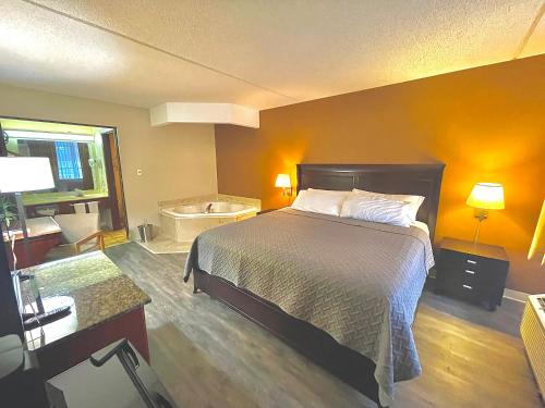 尤里卡斯普林斯Eureka Springs Heritage Motel的一间卧室配有一张床,浴室设有浴缸