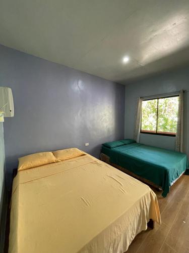 曼巴豪C - Side Inn的一间卧室设有两张床和窗户。
