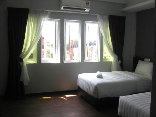 马六甲707 Hotel (Cheng Ho ) Melaka的一间卧室设有两张床和两个窗户。