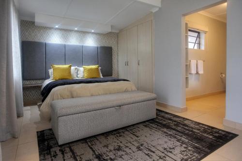 阿多Longhill Lodge的一间卧室配有一张带黄色枕头的大床