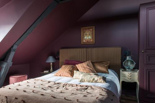 迪耶普La Villa Augustine的一间卧室设有一张紫色墙壁的大床