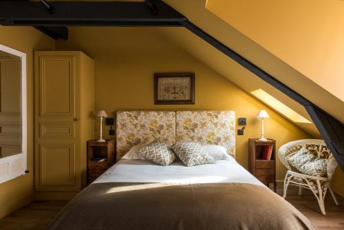 迪耶普La Villa Augustine的一间卧室设有一张黄色墙壁的大床