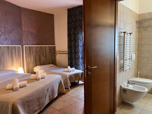 拉齐塞Hotel Renata的酒店客房设有两张床和卫生间。