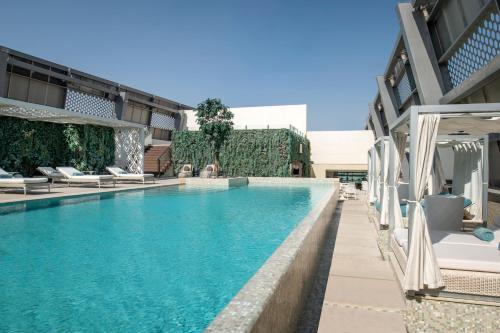 多哈Steigenberger Hotel Doha的一座带躺椅的游泳池,位于大楼旁