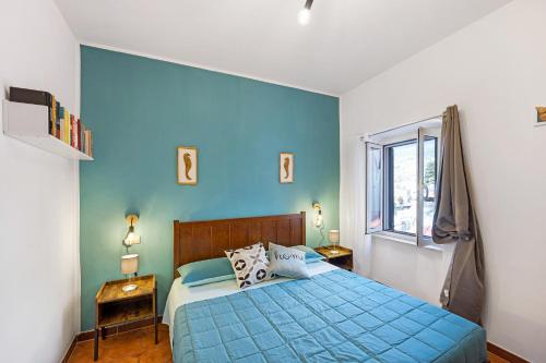 圣雷莫Domus Regina Elena的蓝色的卧室设有床和窗户