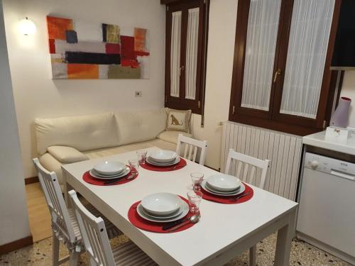 马格拉12 minuti da Venezia appartamento con parcheggio的厨房里一张带盘子和盘子的白色桌子