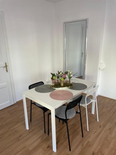 梅尔尼克Apartmán Na Polabí的白色的餐桌,配有椅子和鲜花
