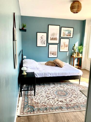 埃皮纳勒Charmant appartement的一间卧室设有一张床和蓝色的墙壁