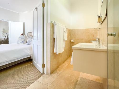 弗朗斯胡克Petit Ermitage的浴室设有床、水槽和镜子