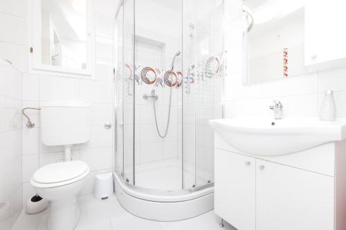 大洛希尼Apartment Morris的带淋浴、卫生间和盥洗盆的白色浴室