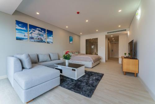 芽庄HighSea GoldCoast Superview Apartment的客厅配有床和沙发