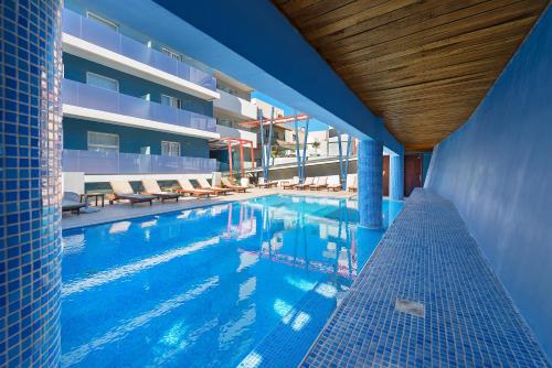 罗德镇塞米勒米斯城市酒店的一座带椅子的游泳池以及一座建筑