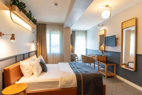 KonakViva La Vita Hotel的配有一张床和一张书桌的酒店客房