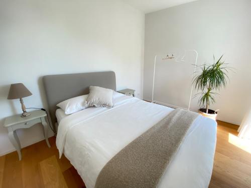 ChâtillonLake View Homestay with Private Room and Bathroom的卧室配有白色大床和植物