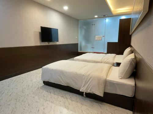 台北苓旅萬年-LIN INN Wan Nian的一间卧室配有一张大床和一台平面电视
