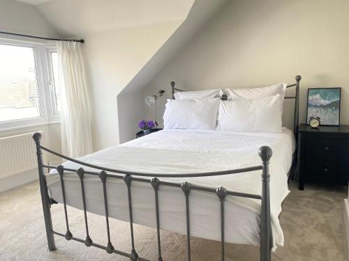 拉姆斯盖特Seaside Apartment的一间卧室配有带白色床单和枕头的床。